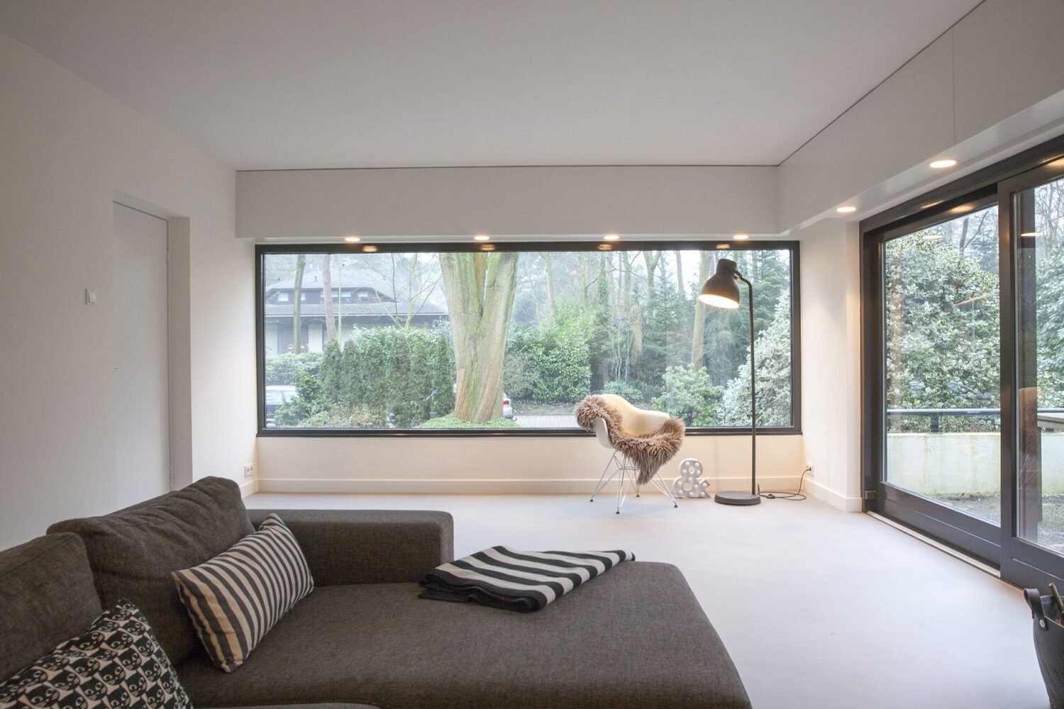 Corestone gietvloer in een woon- en eetkamer met zicht op de tuin (foto EPI Floors)